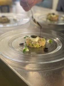 a plate of food on a table with a person holding a spoon at Hotel-Gasthof Waldcafé in Neustift im Stubaital