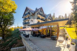 a building with an umbrella in front of it at Czarny Kamień Resort & SPA in Szklarska Poręba