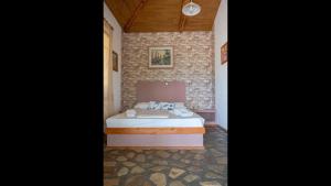 a bedroom with a bed in a brick wall at Beautiful house located on a hill, with a spectacular sea view in Koumeika