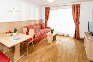 Fini's Apartments في فيبيتينو: غرفة معيشة مع أريكة حمراء وطاولة