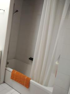y baño con ducha y toalla de color naranja. en Milano 3 Apartment Pal Cigni, en Basiglio