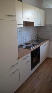 a kitchen with white cabinets and a stove top oven at FeWo Neubert in Bad Kissingen