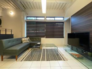 a living room with a couch and a large television at ロハスResort宮浦 in Fukuoka