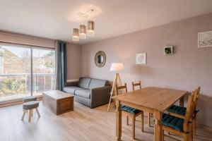 a living room with a table and a couch at Entre Lac et Montagne in Évian-les-Bains