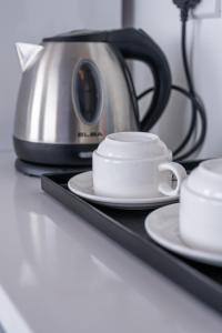 a coffee pot and two cups on a tray at Grace Samudera Hotel in Semporna