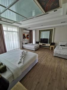 a large room with two beds and a flat screen tv at A-Te Chumphon Hotel - SHA Plus in Chumphon