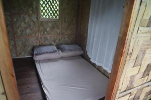 Cama en habitación pequeña con ventana en MIRA AgroPark en Tanay