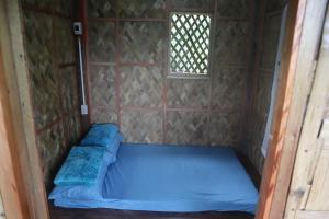 a bed in a small room with a window at MIRA AgroPark in Tanay