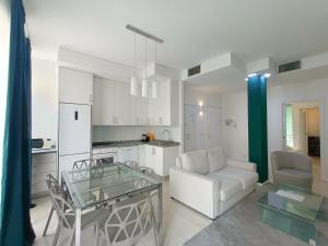a kitchen and a living room with a glass table at Elegant Flat for 6 with 2 Balconies in Milan