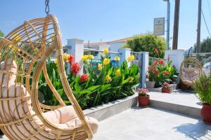 einen Korbstuhl vor einem Garten mit Blumen in der Unterkunft Ninemia Studios in Limenas