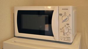 a white microwave oven sitting on top of a shelf at RakutenSTAY x Shamaison Osaka Dekijima - 303 in Osaka