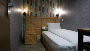 a bedroom with two beds and a wooden headboard at NYS Loft Hotel in Taipei
