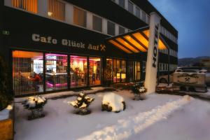 un edificio con nieve frente a una tienda en Hotel Fohnsdorf, en Fohnsdorf