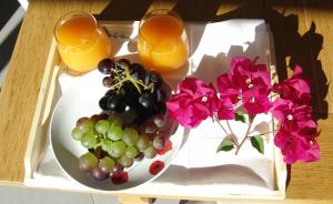 taca z winogronami i kwiatami oraz dwa kieliszki soku pomarańczowego w obiekcie Quinta de Santa Marinha w mieście Arcos de Valdevez