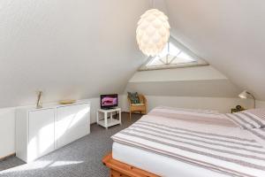Schlafzimmer im Dachgeschoss mit einem Bett und einem Fenster in der Unterkunft Haus Strandlooper in Neuharlingersiel