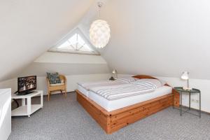 a bedroom with a bed and a desk and a window at Haus Strandlooper in Neuharlingersiel