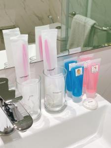 a bathroom counter with three glass containers on a sink at Miloft Sathorn Hotel - SHA Plus Certified in Bangkok