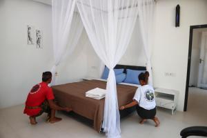 two people are standing around a bed in a room at BALI AMED FEEL HOME VILLA in Amed