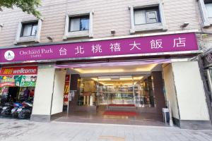 Hotel Orchard Park - Taipei في تايبيه: متجر به علامة أرجوانية على واجهة المبنى