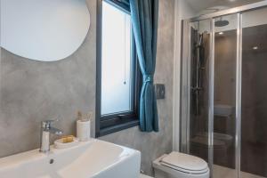 a bathroom with a sink and a toilet and a window at Fornella Camping & Wellness family resort in San Felice del Benaco