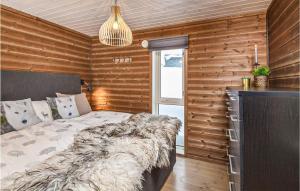 1 dormitorio con 1 cama en una habitación con paredes de madera en 4 Bedroom Amazing Home In Lillehammer en Lillehammer