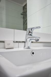 شقق غاردنس سنتر هوليدي في كيب تاون: بالوعة الحمام مع وجود صنبور أمام المرآة