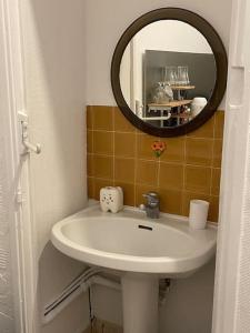 y baño con lavabo y espejo. en Le studio de la mer en Trouville-sur-Mer