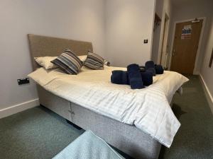 a bed in a bedroom with blue pillows on it at No 9 Ocean Cabins - Saundersfoot Harbour - Saundersfoot in Saundersfoot