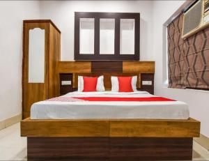 Un dormitorio con una gran cama de madera con almohadas rojas en Hotel Bansal Residency, Sirsa, en Sirsa