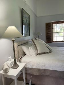 a bedroom with a bed and a table with a lamp at The Coach House on River and Park in Mudgee