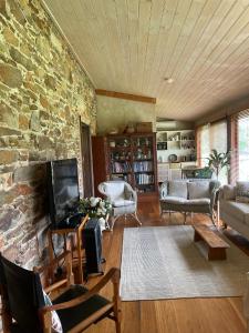 a living room with a stone wall at The Coach House on River and Park in Mudgee