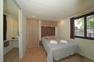 a bedroom with a bed with two towels on it at Fornella Camping & Wellness family resort in San Felice del Benaco