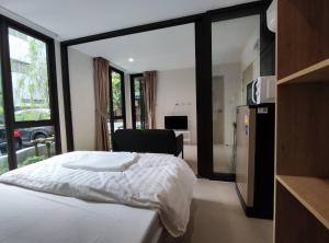 a bedroom with a bed and a kitchen with a window at POP Heritage Residence in Bangkok