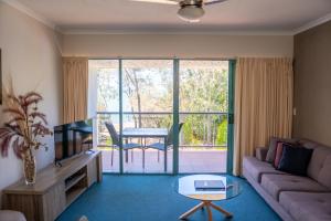 - un salon avec un canapé et une table dans l'établissement Shelly Bay Resort, à Hervey Bay