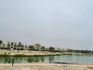 a beach with people and buildings and a body of water at one bedroom villa in Salalah