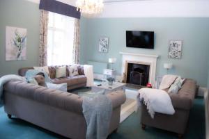 a living room with two couches and a fireplace at Redmayne House in Lake District National Park