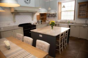 a kitchen with a large island with a table and chairs at Redmayne House in Lake District National Park