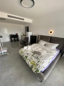 a bedroom with a bed and a chair and a table at studio ilanit in Karmiel