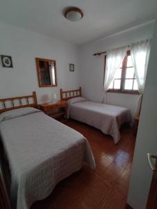 a bedroom with two beds and two windows at Apartamento 2 dormitorios cerca de la playa en Puerto del Carmen in Puerto del Carmen