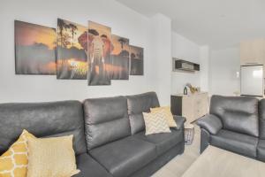 a living room with a leather couch and a table at MILLION APARTAMENT in Málaga