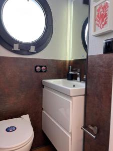 een badkamer met een toilet, een wastafel en een raam bij Casas Flotantes - Boatvillage in Ayamonte