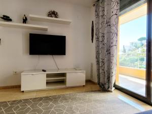 sala de estar con TV de pantalla plana en la pared en Apartament Lloret de Mar with terrace en Lloret de Mar