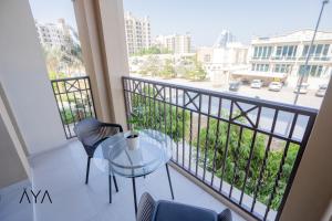 een balkon met een glazen tafel en uitzicht op een straat bij AYA Boutique - Rahaal 2, Madinat Jumeirah Living in Dubai