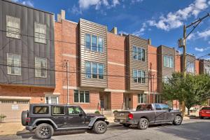 two cars parked in front of a brick building at Chic Philly Townhome Less Than 3 Mi to Center City! in Philadelphia