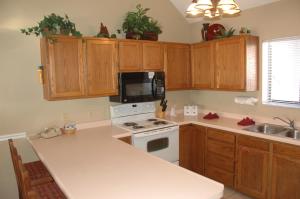 a kitchen with wooden cabinets and a white stove top oven at Powder Ridge Village, a VRI resort in Powder Mountain West