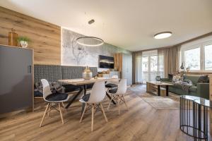 a dining room and living room with a table and chairs at Hotel Viktoria & Landhaus Joggl in Mayrhofen