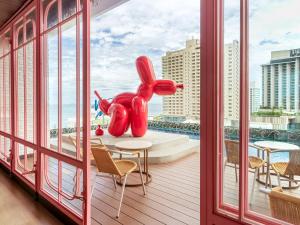 a balcony with a large red elephant statue on it at Mytt Hotel Pattaya - SHA Extra Plus in Pattaya