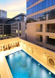 a large swimming pool on the side of a building at Al Fares Luxury furnished Apartment-Damac Tower in Amman