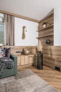 a living room with a green couch and a window at Hotel Viktoria & Landhaus Joggl in Mayrhofen