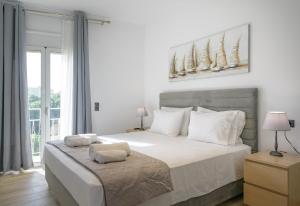 une chambre blanche avec un grand lit et une fenêtre dans l'établissement Theotokopoulos Park Renovated Apartment, à Héraklion